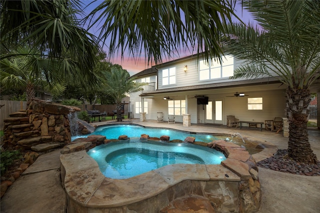 view of pool with a patio, a pool with connected hot tub, fence, and a ceiling fan