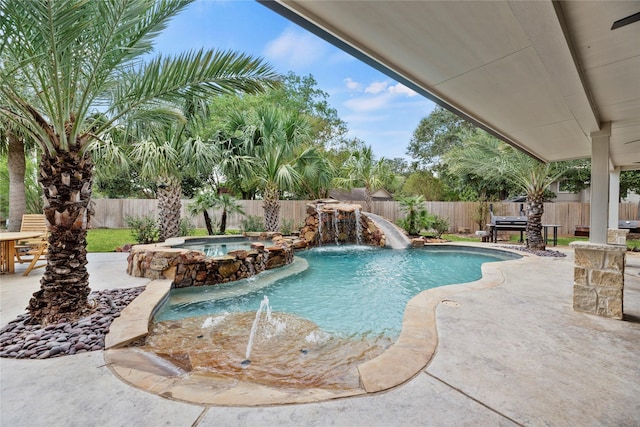 view of pool featuring a fenced backyard, a pool with connected hot tub, and a patio