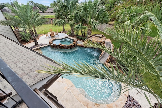 view of pool with a patio area, a fenced backyard, a pool with connected hot tub, and a lawn