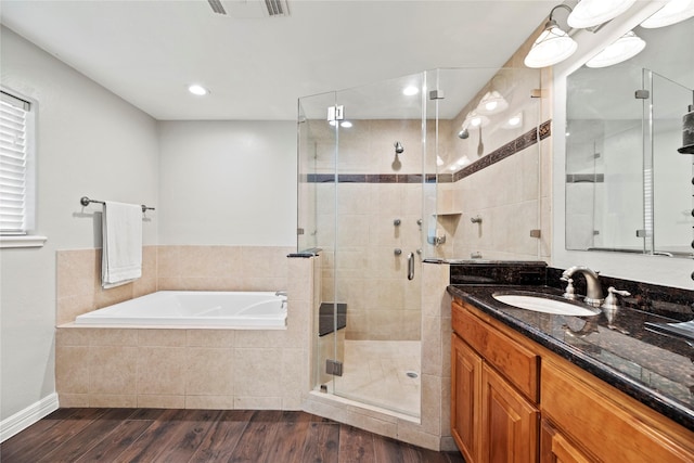 full bath with wood finished floors, visible vents, vanity, a shower stall, and a bath