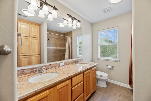 full bath with toilet, baseboards, visible vents, and a sink