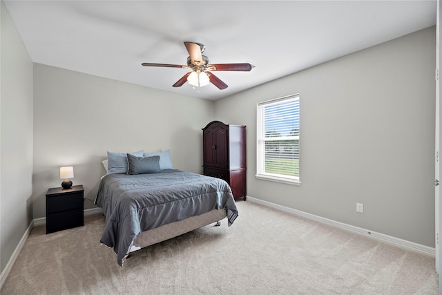 bedroom with light carpet, ceiling fan, and baseboards