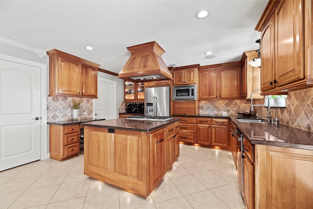 kitchen with a center island, stainless steel appliances, a sink, dark stone counters, and premium range hood