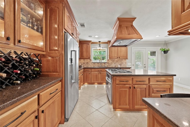 kitchen with island range hood, high quality fridge, glass insert cabinets, and visible vents