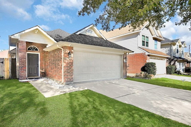 view of front facade with driveway, a shingled roof, a front lawn, and brick siding