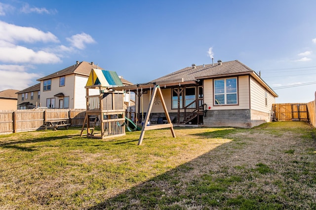 rear view of house featuring a fenced backyard, a playground, and a yard