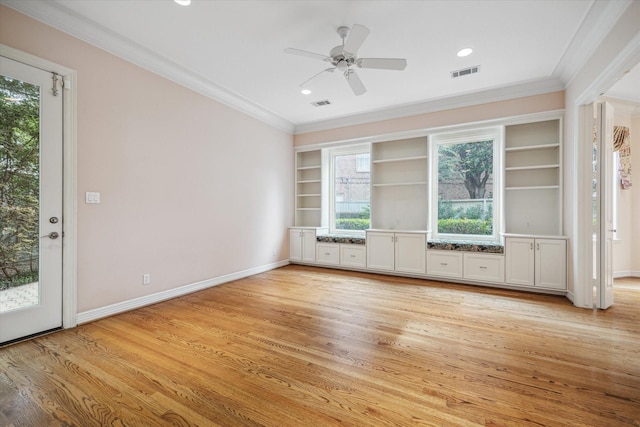 interior space featuring light wood finished floors, visible vents, and crown molding