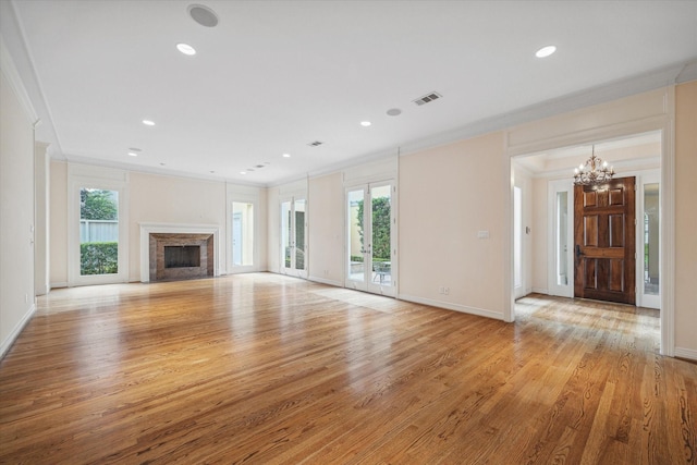 unfurnished living room with ornamental molding, a healthy amount of sunlight, and a fireplace