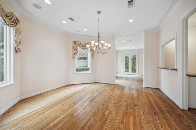 empty room featuring ornamental molding, visible vents, baseboards, and wood finished floors