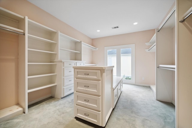 walk in closet with light colored carpet and visible vents