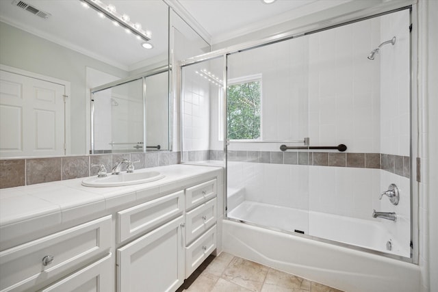 bathroom featuring bath / shower combo with glass door, vanity, visible vents, and crown molding