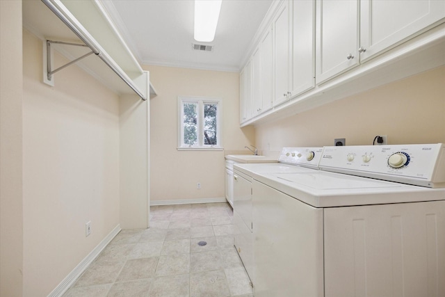 washroom featuring washing machine and dryer, cabinet space, visible vents, and baseboards