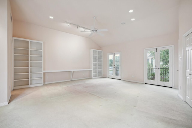 empty room featuring lofted ceiling, french doors, light colored carpet, and plenty of natural light