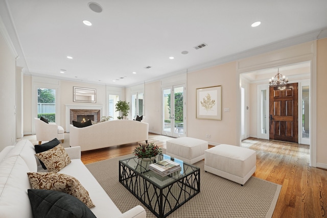 living area with light wood-type flooring, ornamental molding, and a wealth of natural light