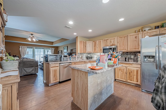 kitchen with a peninsula, visible vents, open floor plan, light countertops, and appliances with stainless steel finishes