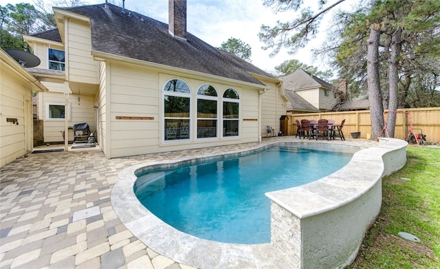 view of pool with a patio, outdoor dining area, and fence