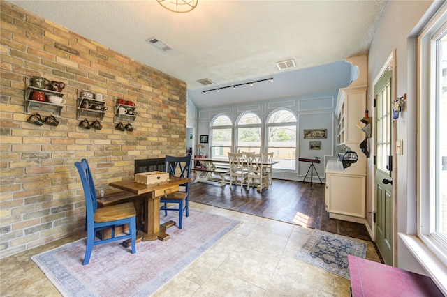 dining space with visible vents, a textured ceiling, and tile patterned floors