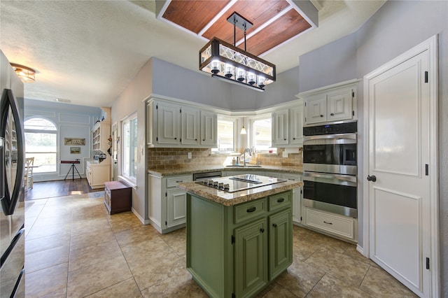 kitchen featuring a sink, a kitchen island, appliances with stainless steel finishes, backsplash, and green cabinetry