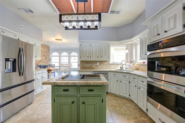 kitchen with appliances with stainless steel finishes, green cabinetry, a sink, and visible vents