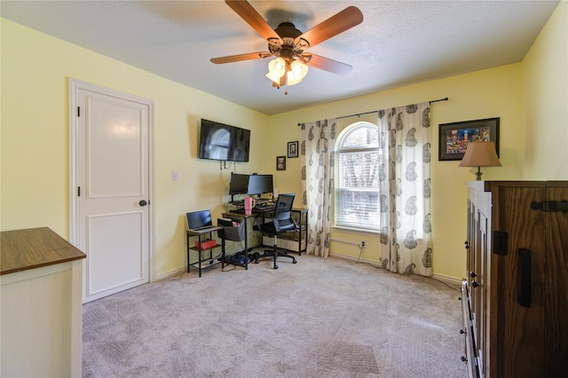 office area with baseboards, a textured ceiling, a ceiling fan, and carpet flooring