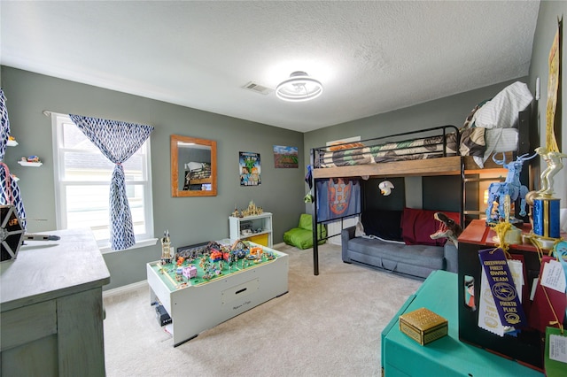 bedroom with a textured ceiling, visible vents, and light colored carpet