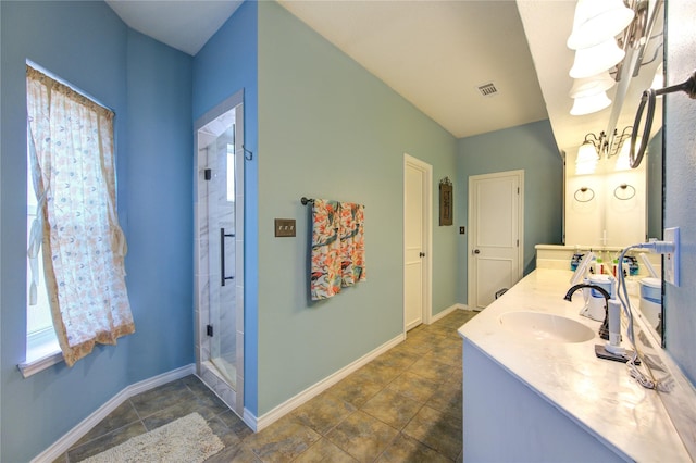 full bath with double vanity, baseboards, visible vents, a shower stall, and a sink