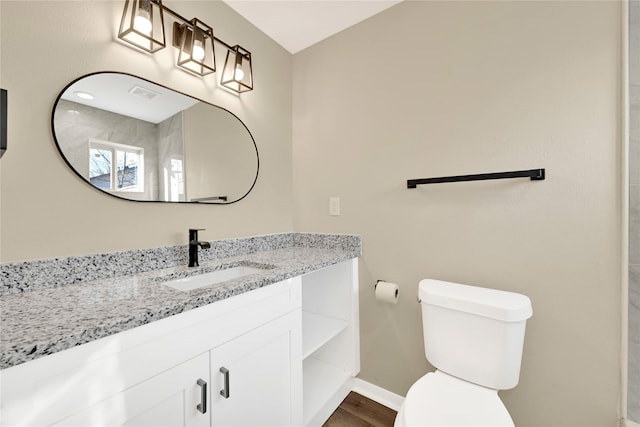 bathroom with visible vents, baseboards, toilet, wood finished floors, and vanity