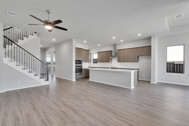 2920 Apple Rose, Katy, TX 77493 - kitchen featuring stainless steel appliances, open floor plan, wall chimney exhaust hood, and light wood-style flooring