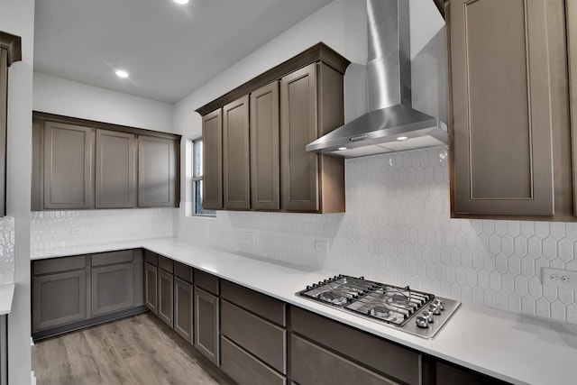2920 Apple Rose, Katy, TX 77493 - kitchen featuring light countertops, decorative backsplash, light wood-style flooring, stainless steel gas stovetop, and wall chimney exhaust hood