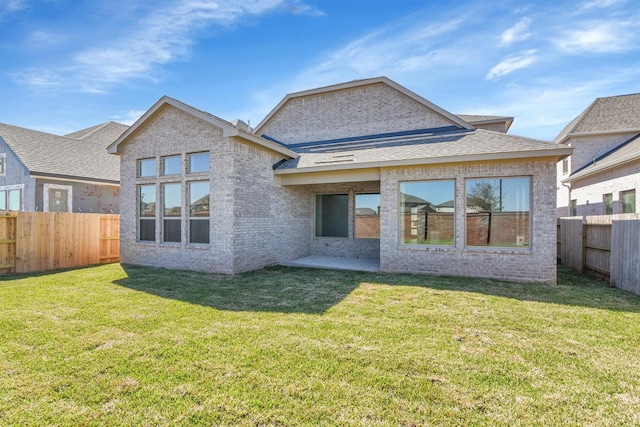 2920 Apple Rose, Katy, TX 77493 - back of property featuring brick siding, a patio, a fenced backyard, and a lawn