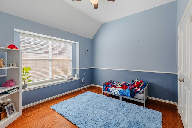 rec room with lofted ceiling, ceiling fan, baseboards, and wood finished floors