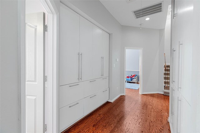 corridor with attic access, baseboards, visible vents, wood finished floors, and recessed lighting