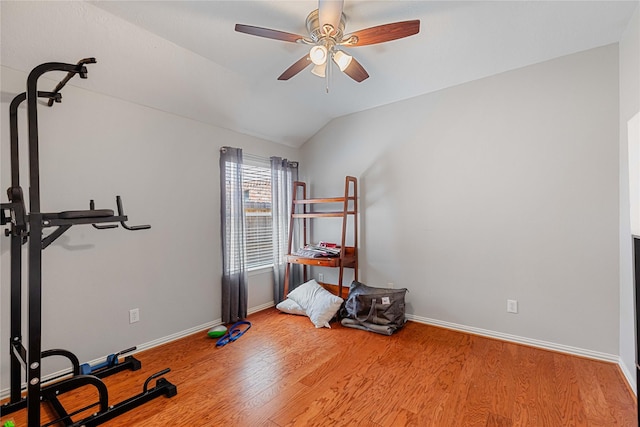 workout area with ceiling fan, vaulted ceiling, baseboards, and wood finished floors