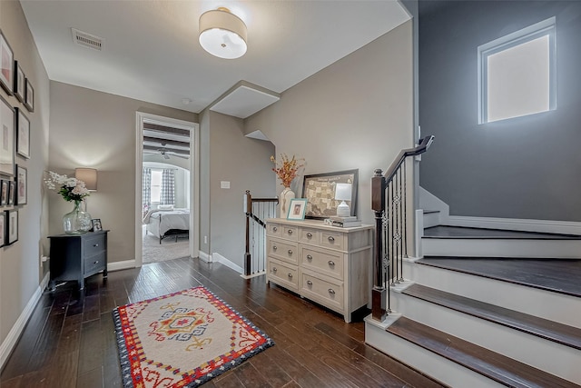 foyer entrance featuring stairway, baseboards, visible vents, and dark wood-type flooring