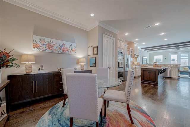 dining room with dark wood-style floors, recessed lighting, visible vents, and ornamental molding