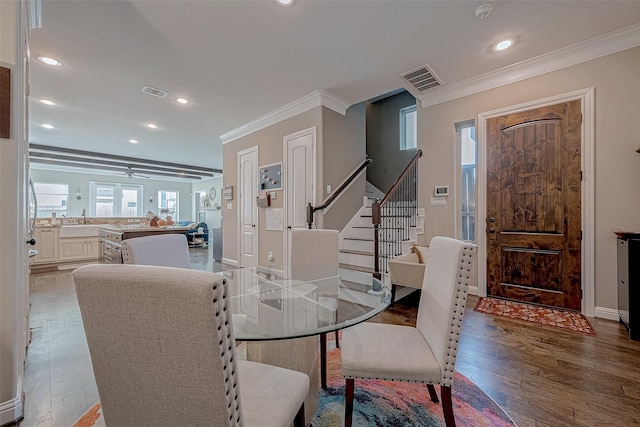 dining room with crown molding, recessed lighting, visible vents, wood finished floors, and stairs