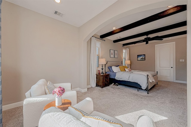 bedroom featuring arched walkways, light colored carpet, visible vents, baseboards, and beam ceiling