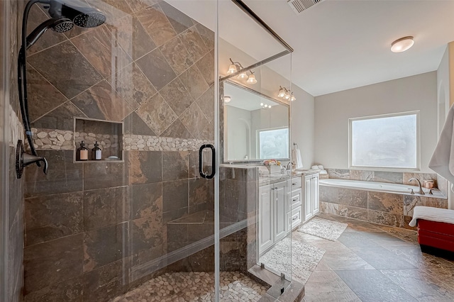 bathroom with stone tile floors, visible vents, a stall shower, vanity, and a bath