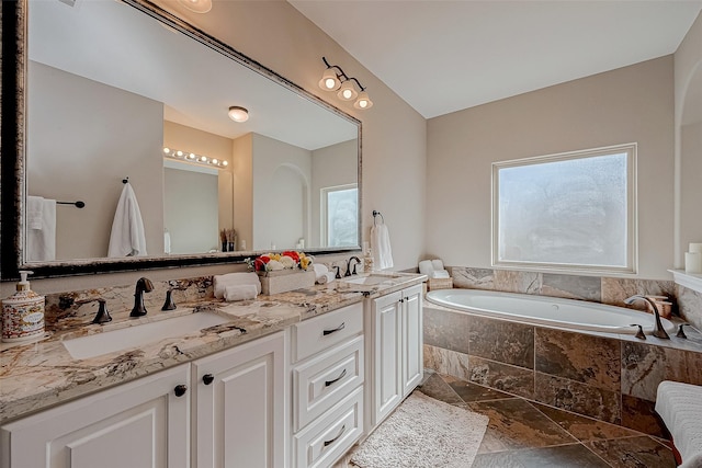 full bathroom with double vanity, a sink, and a bath