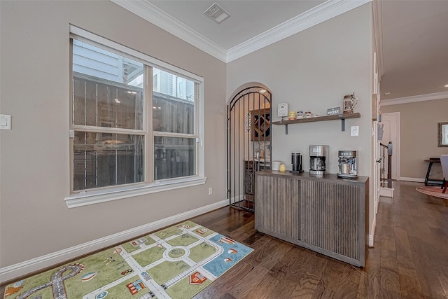 interior space featuring ornamental molding, dark wood-style flooring, visible vents, and baseboards