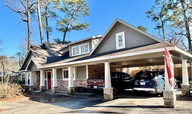 craftsman-style house with driveway and brick siding