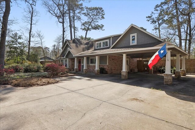 craftsman inspired home featuring an attached carport, concrete driveway, and fence