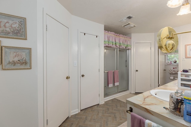 bathroom with a stall shower, a closet, visible vents, and vanity