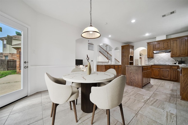 dining room with arched walkways, visible vents, stairway, and recessed lighting