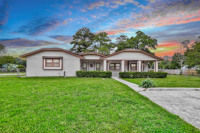 128 Legend Ln, Livingston, TX 77351 - view of front facade featuring covered porch, brick siding, fence, and a front yard