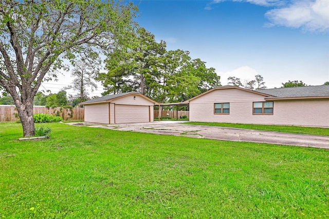 128 Legend Ln, Livingston, TX 77351 - view of front of home featuring an outdoor structure, a front lawn, fence, and a detached garage