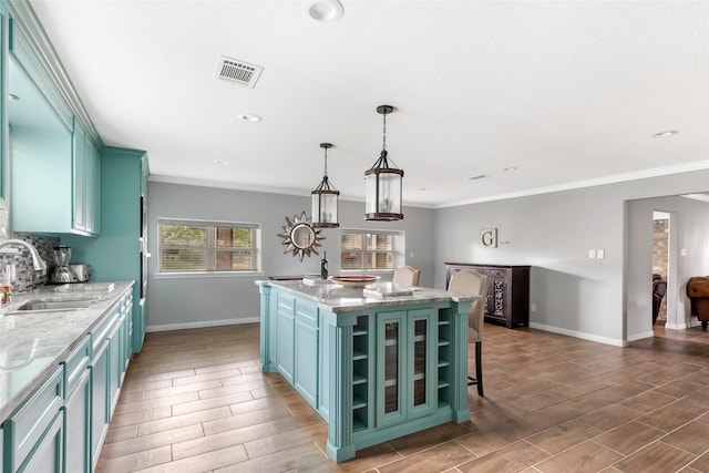 128 Legend Ln, Livingston, TX 77351 - kitchen with wood tiled floor, visible vents, a center island with sink, a sink, and baseboards