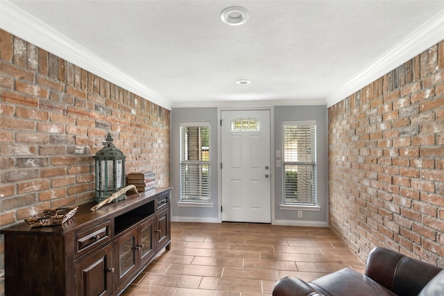 128 Legend Ln, Livingston, TX 77351 - entrance foyer featuring a textured ceiling, ornamental molding, baseboards, and brick wall