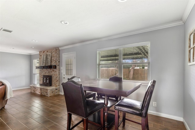 128 Legend Ln, Livingston, TX 77351 - dining space featuring crown molding, baseboards, dark wood-type flooring, and a fireplace