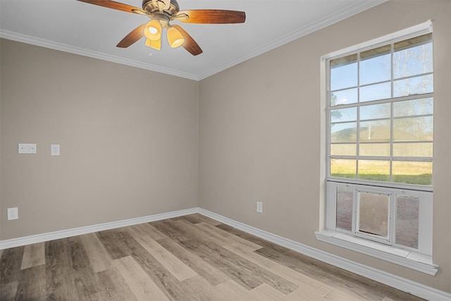 empty room featuring light wood-style floors, a ceiling fan, baseboards, and crown molding